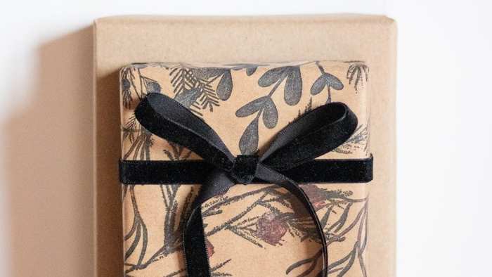 A kraft-paper wrapped corporate gift box tied with a black ribbon