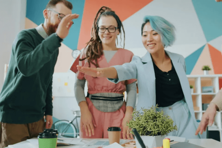 Colleagues giving a high five in a bright office