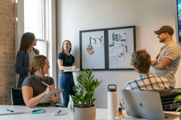 A small team talking in a sunlit office