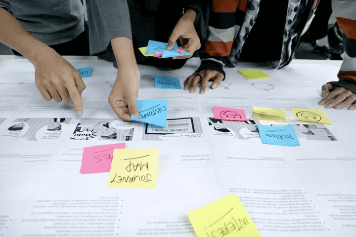 Hands placing sticky notes on a planning board