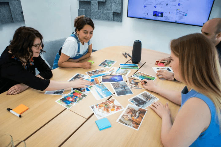 A team sorting photos and cards on a meeting table